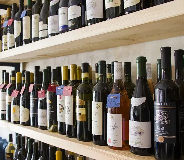 Varias botellas de vino están alineadas en un estante, incluida una botella de rosado.