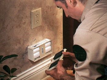 Un hombre está trabajando en una toma eléctrica en una pared.