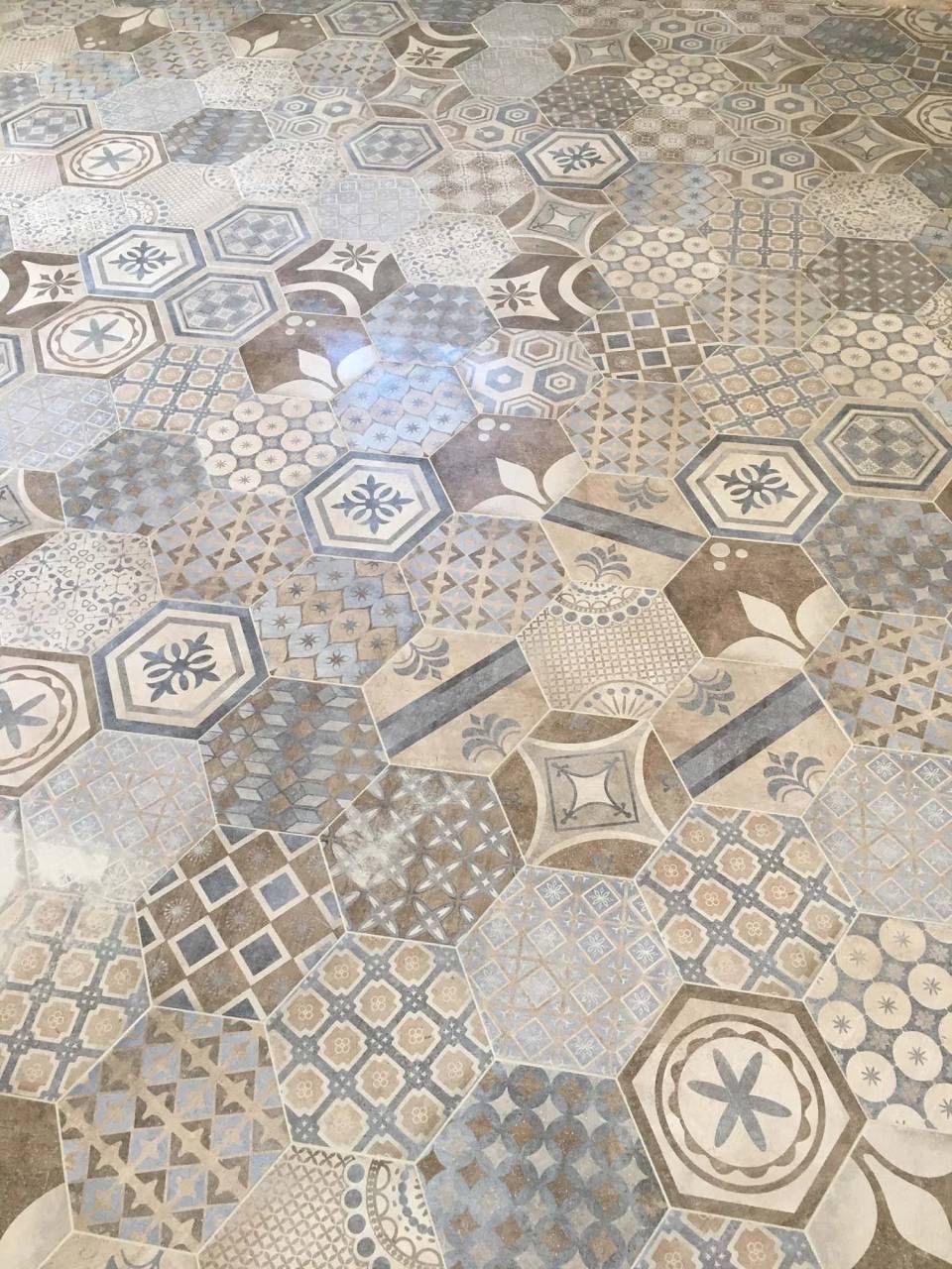 Carrelage à motifs géométriques dans les tons de brun, de gris et de bleu.