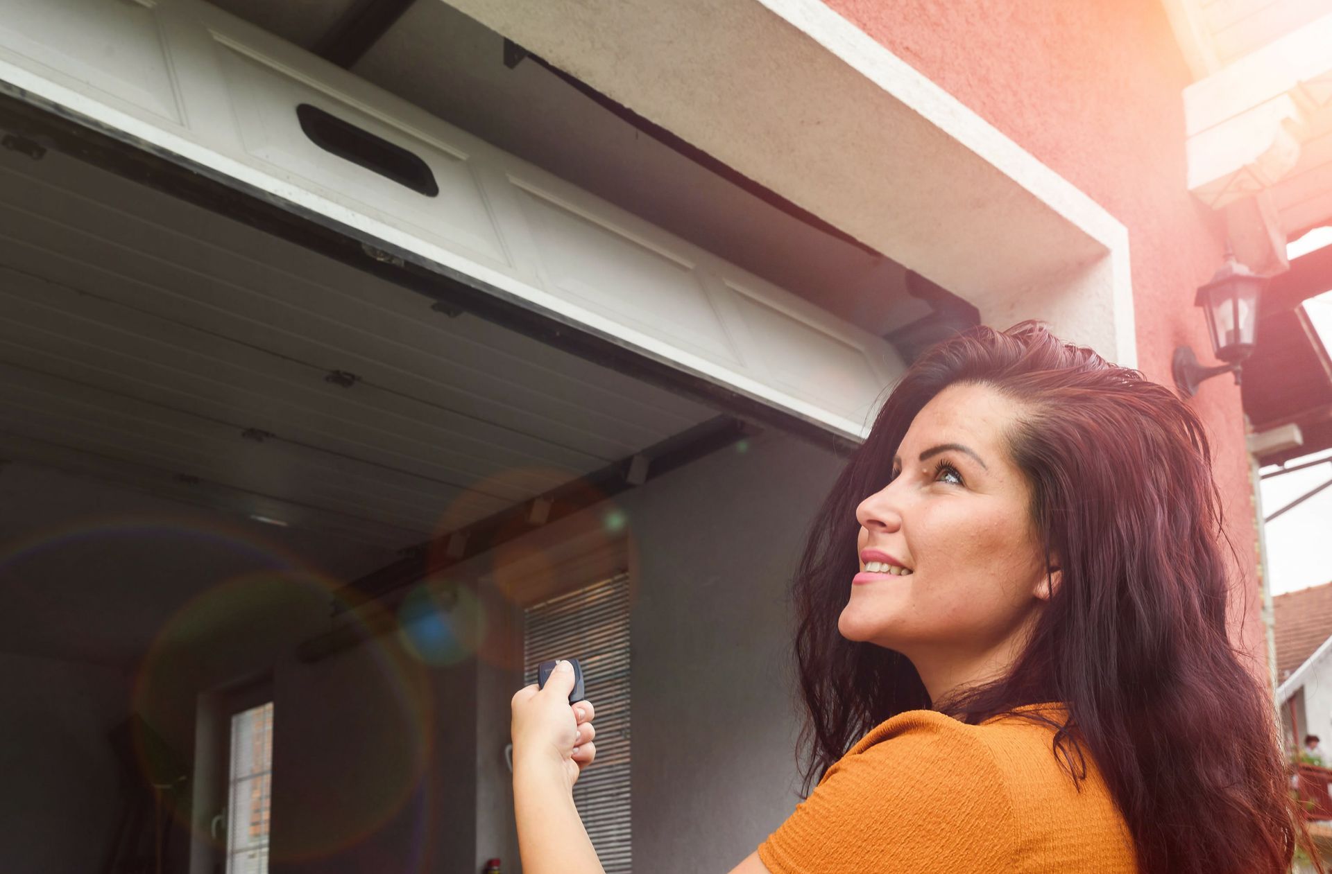 Une femme ouvrant une porte de garage avec une télécommande