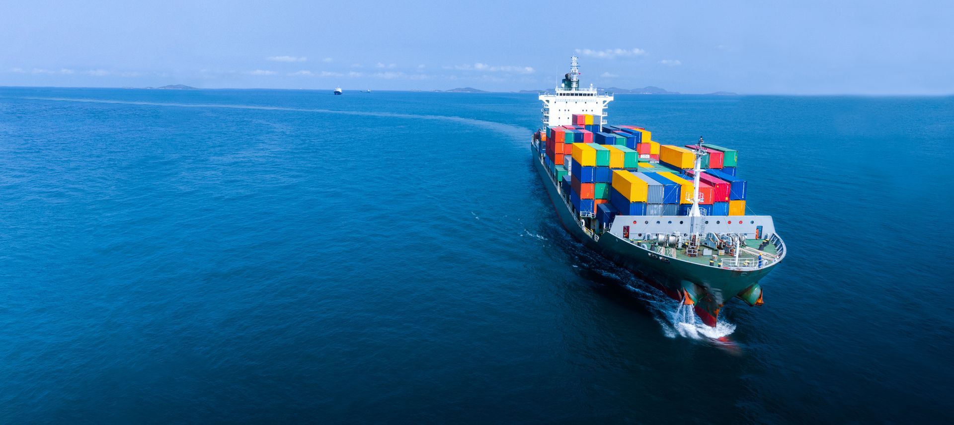 Un gran barco portacontenedores flota sobre una gran masa de agua.