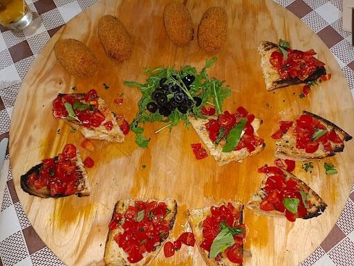 Una tabla de cortar de madera con una variedad de alimentos sobre ella.