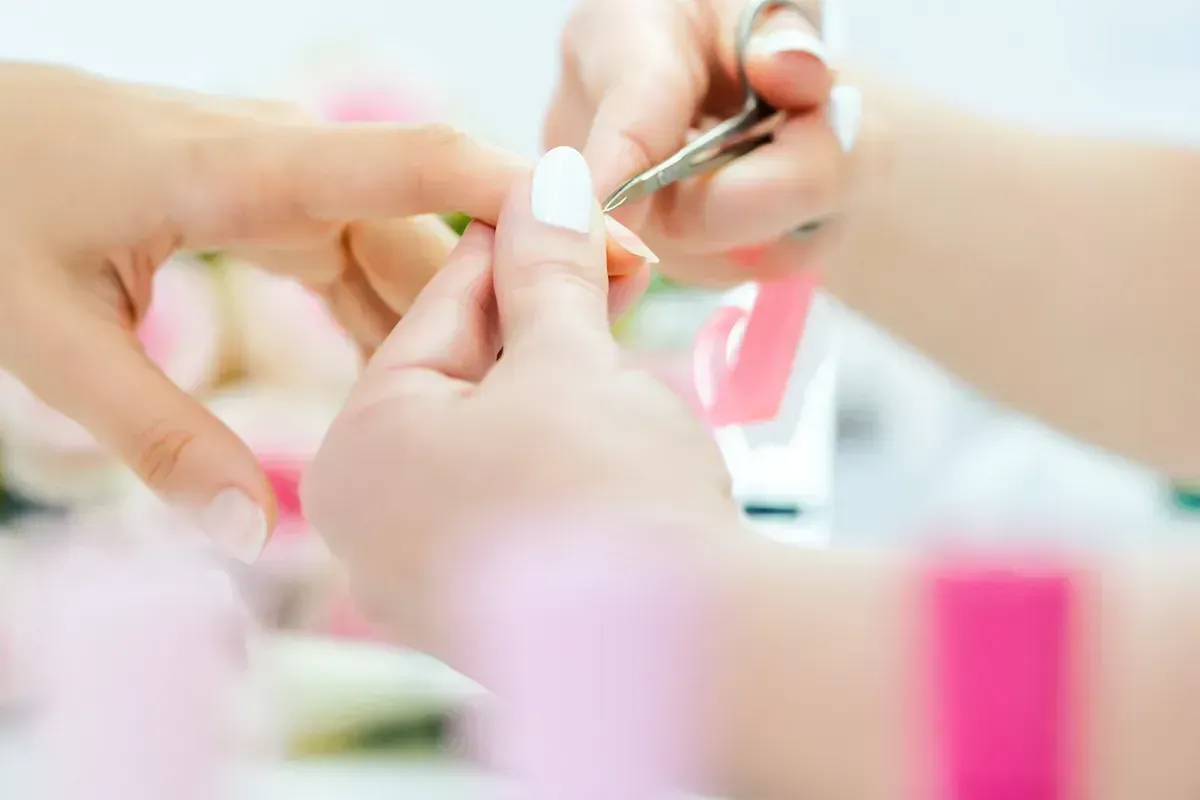 Una mujer se está pintando las uñas con un artista de uñas.