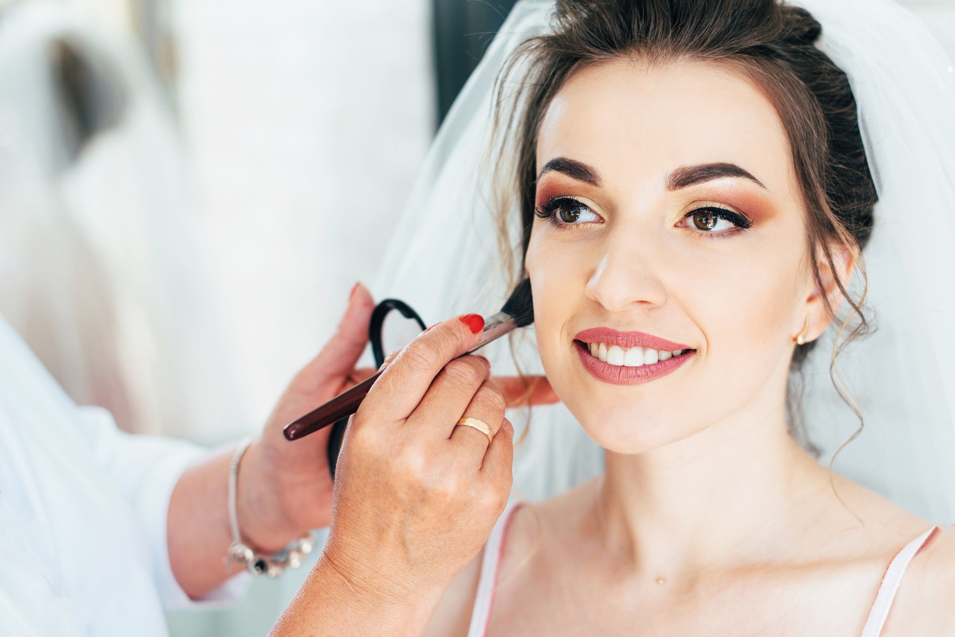 Una mujer se está maquillando con un maquillador.