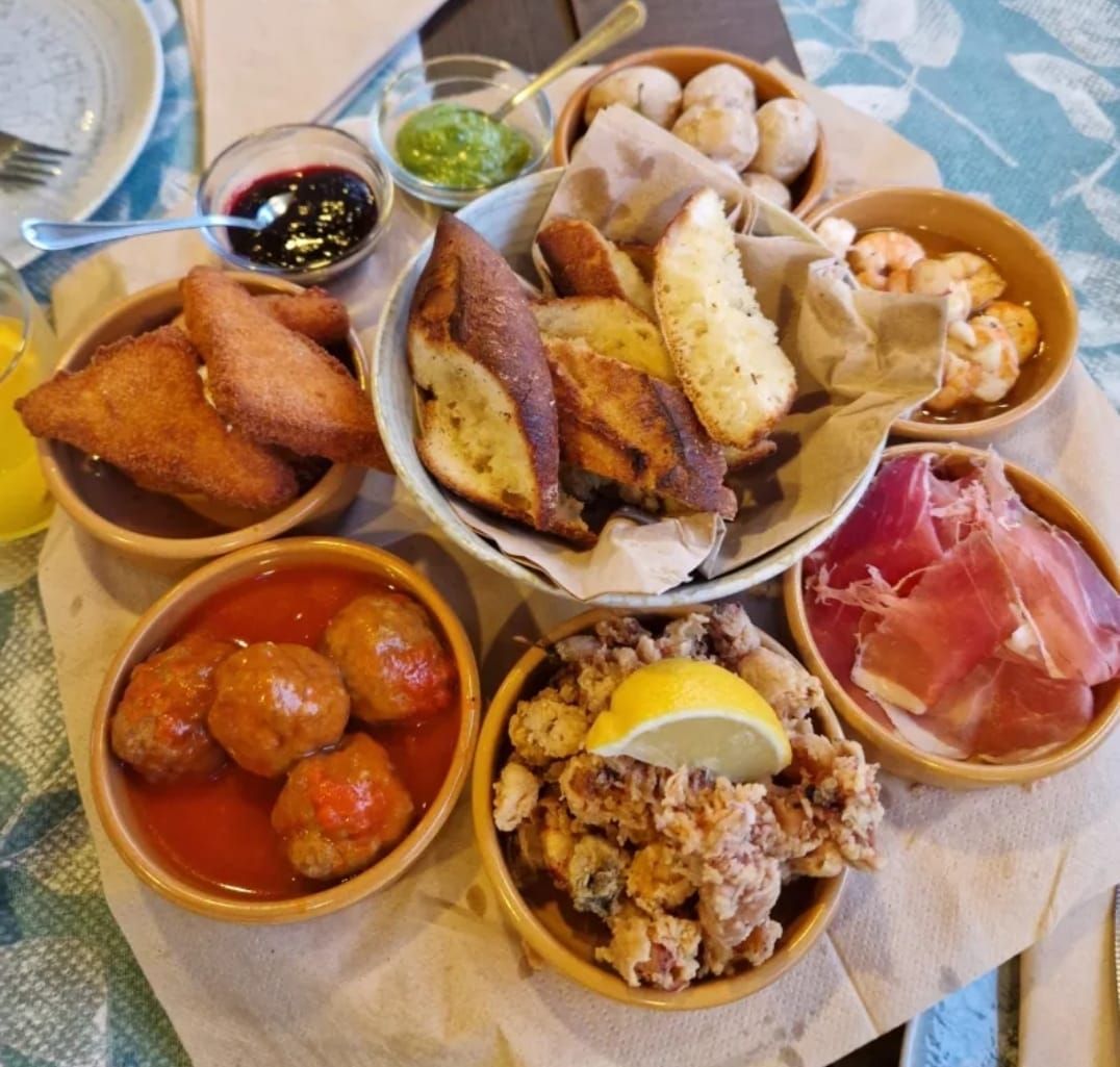 Una mesa cubierta con cuencos de comida que incluían albóndigas y pan.