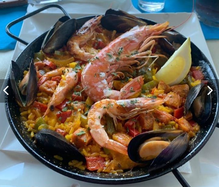 Una paella con camarones, mejillones y verduras