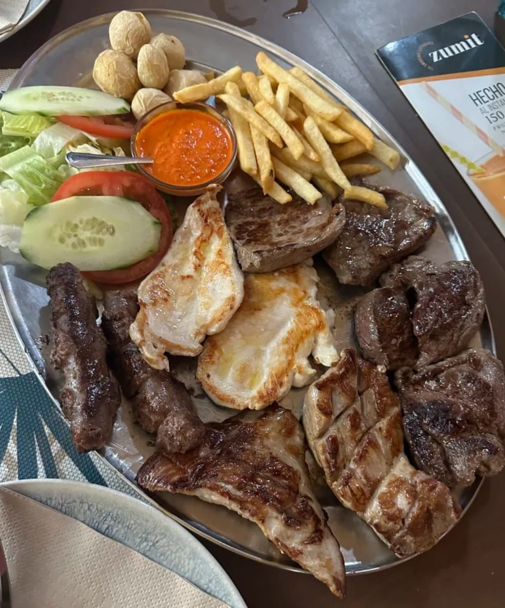 Un plato de carne y patatas fritas en una mesa