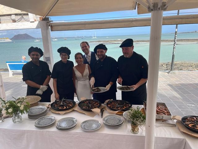 Un grupo de personas de pie alrededor de una mesa con platos de comida.