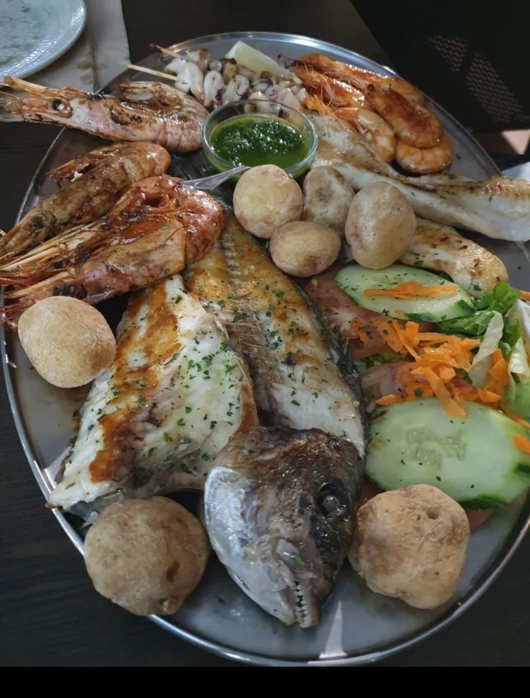 Un plato de pescado y verduras en una mesa.