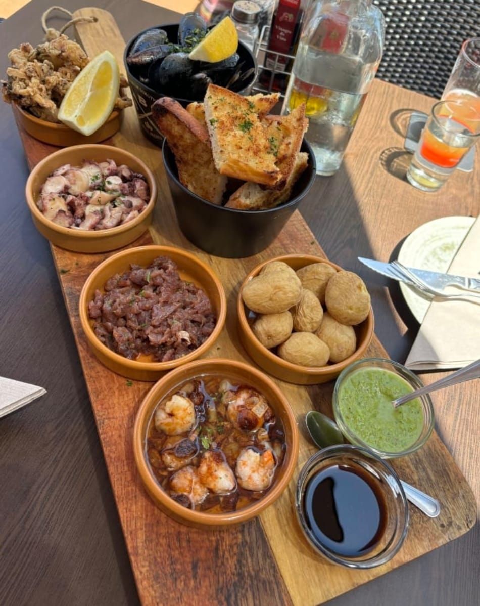 Una tabla de cortar de madera con tazones de comida sobre ella