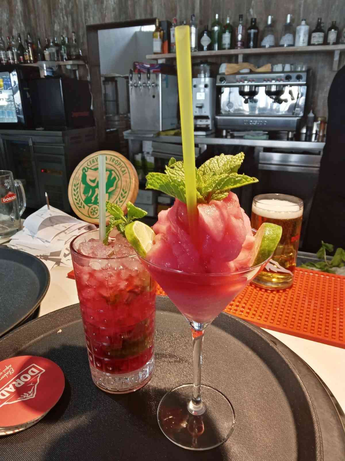 Hay dos bebidas en una bandeja sobre una mesa en un restaurante.