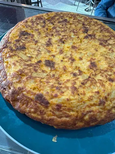 Cucharas llenas de tomates y pimientos verdes sobre una mesa