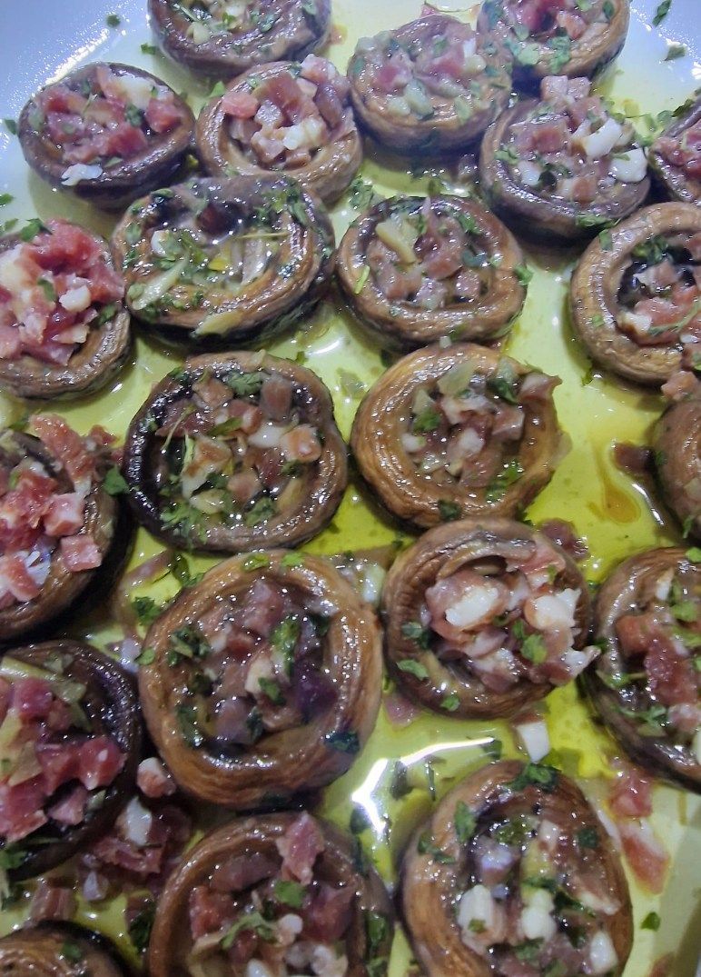 Cucharas llenas de tomates y pimientos verdes sobre una mesa