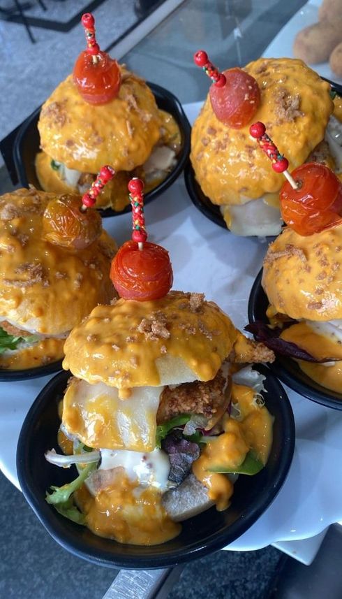 Cucharas llenas de tomates y pimientos verdes sobre una mesa