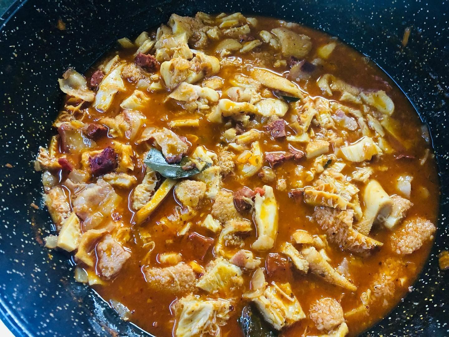 Una bandeja de cucharas llenas de comida sobre una mesa.