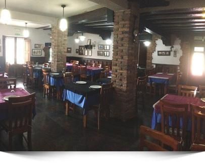 Un restaurante con mesas, sillas y platos.