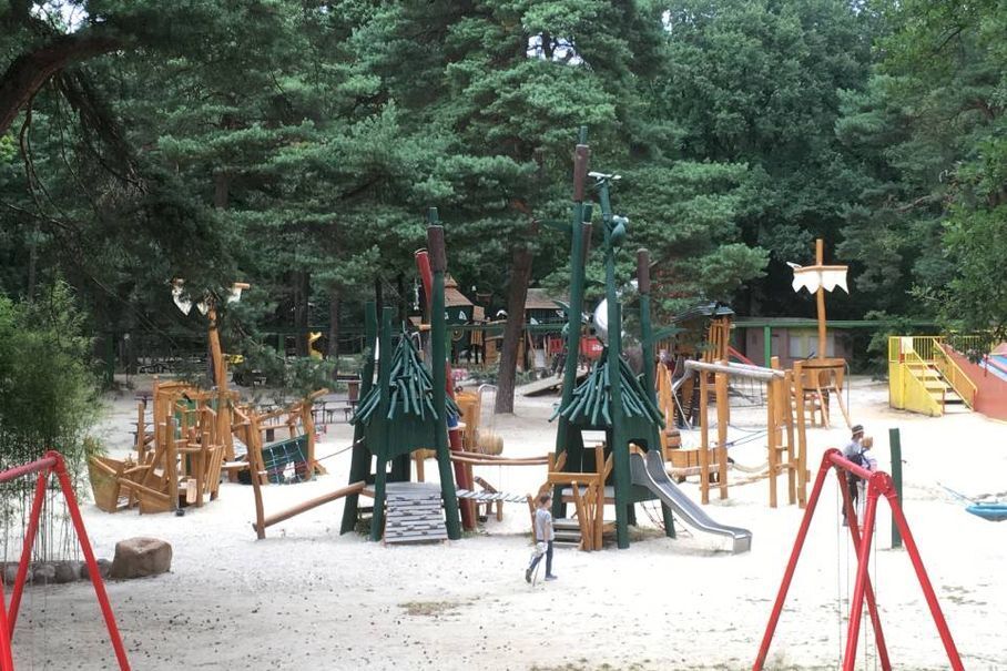 Eine zufriedene Familie besucht einen großen Kinderspielplatz nahe Willich.