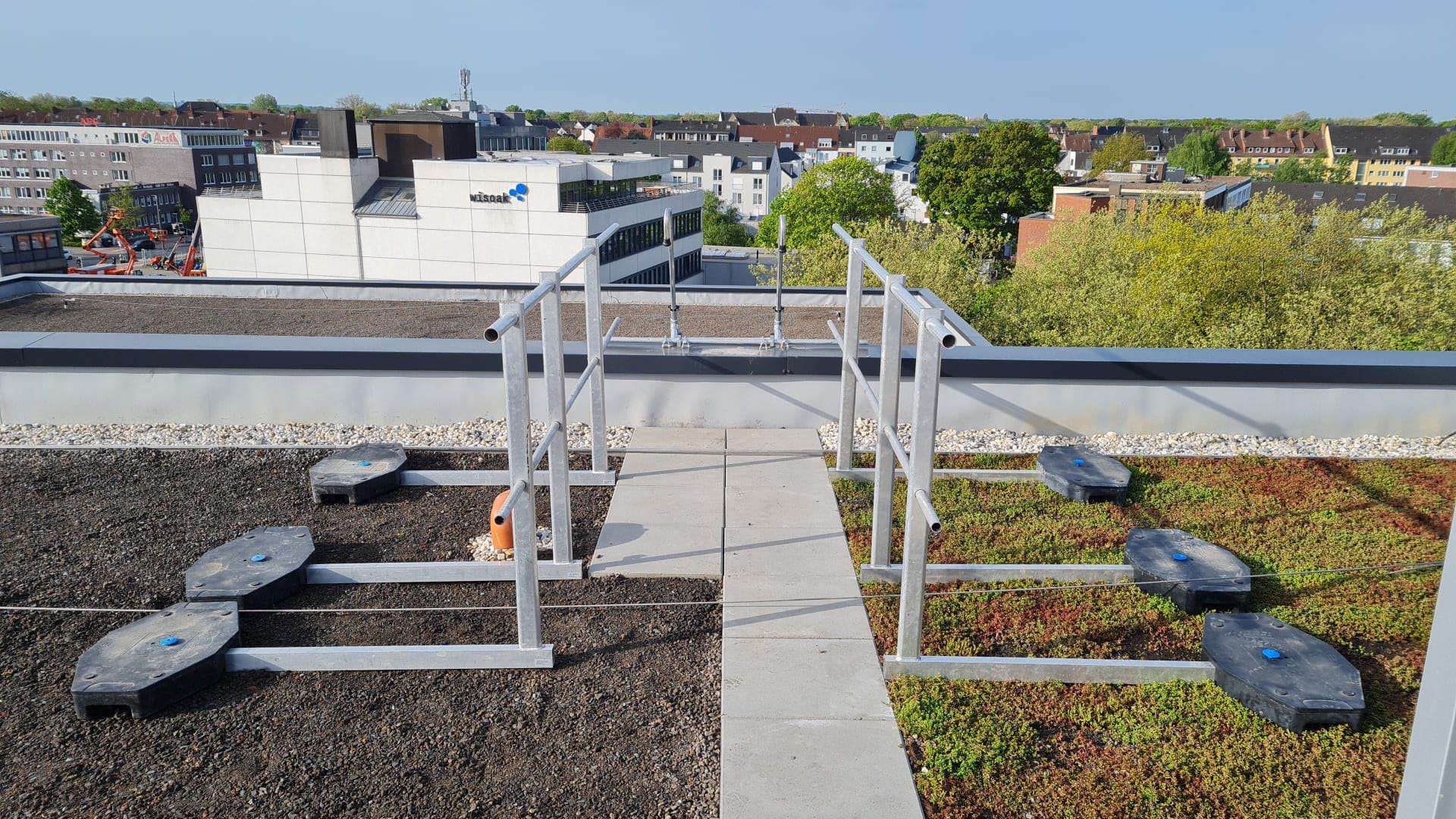 Ein Dachsteg mit Geländer, der zu einem Gründach führt.