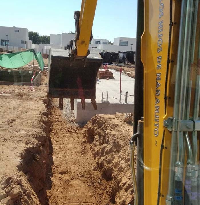 Una excavadora amarilla está cavando un hoyo en la tierra.