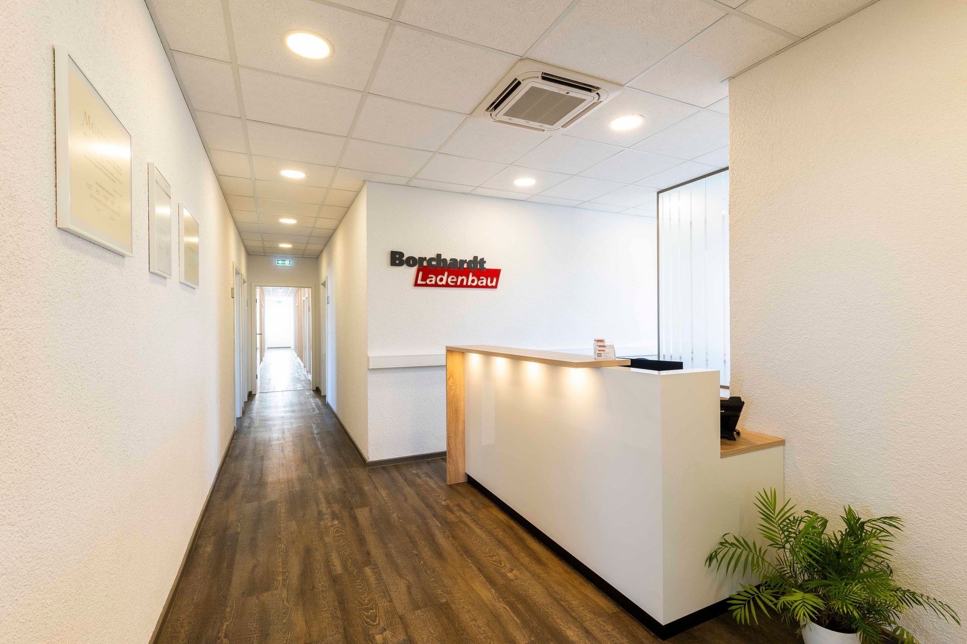 ein langer Flur mit einer Rezeption in der Mitte.