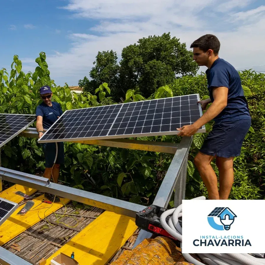 Dos personas instalando paneles solares en un tejado, camisas azules, día soleado.