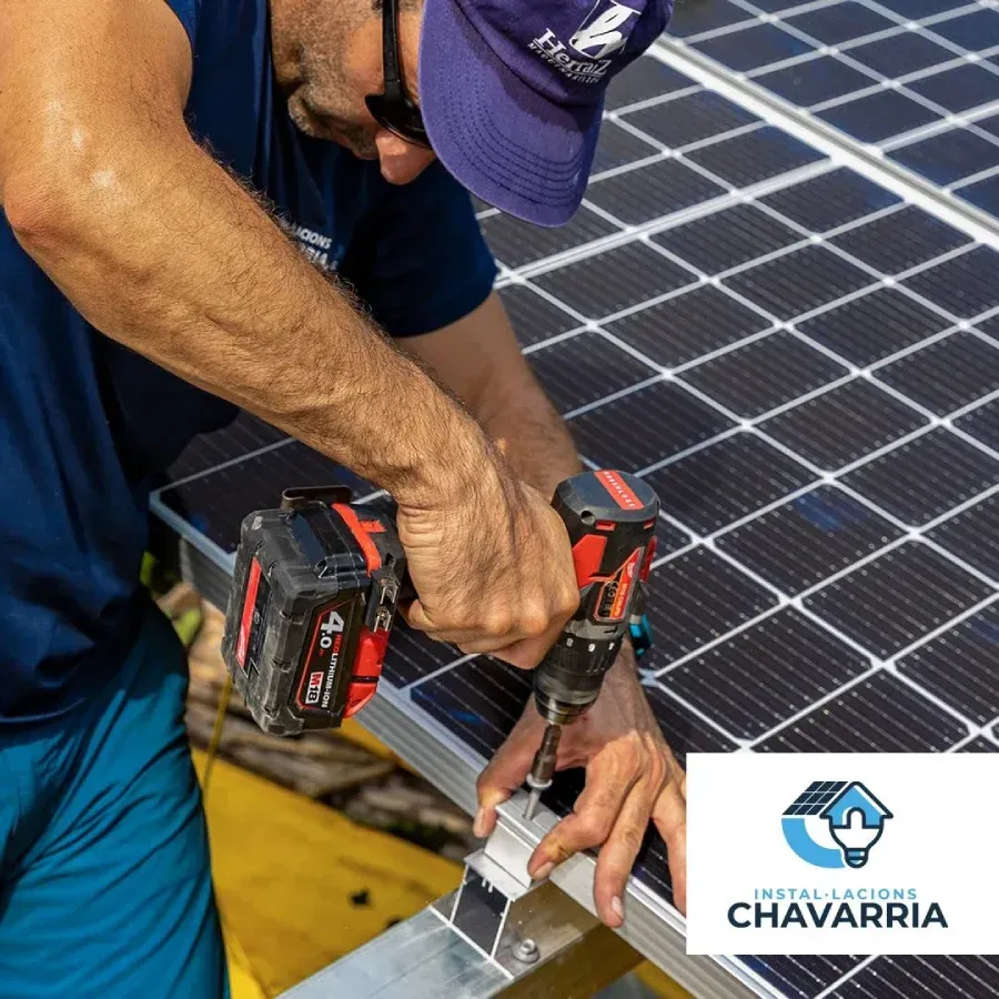 Persona instalando paneles solares con un taladro.