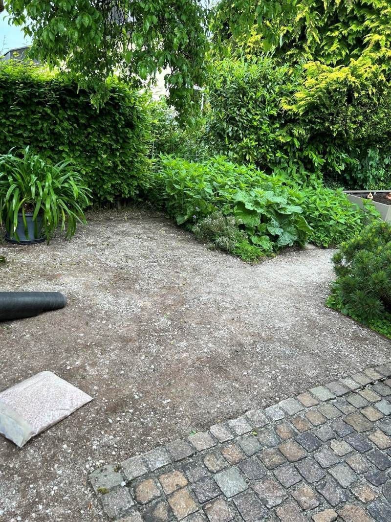 In der Mitte eines Gartens befindet sich ein Ziegelweg. Foto  von Edi Gartenunterhalt.