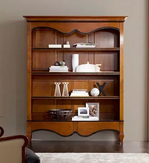 Una gran estantería de madera llena de libros y jarrones.