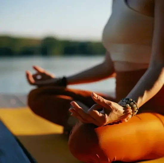 Una mujer está sentada en posición de loto sobre una estera de yoga.