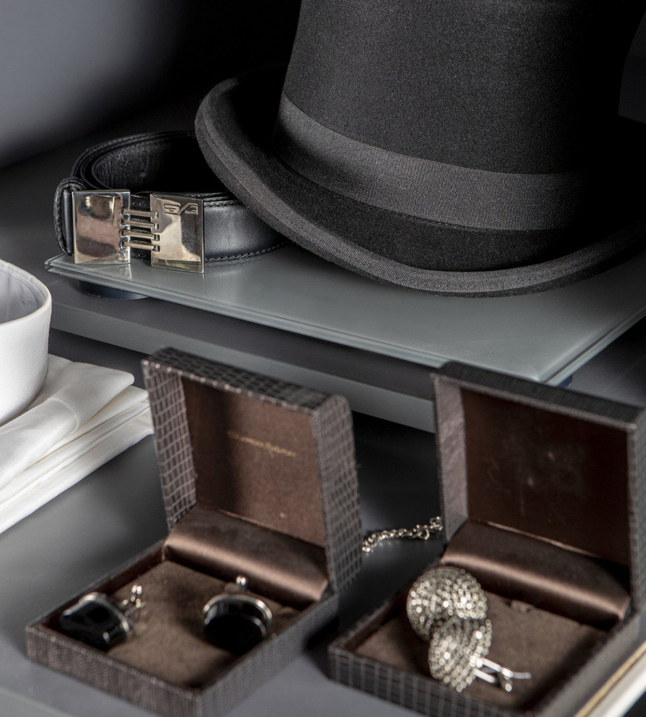 Dos cajas de gemelos y un sombrero sobre una mesa