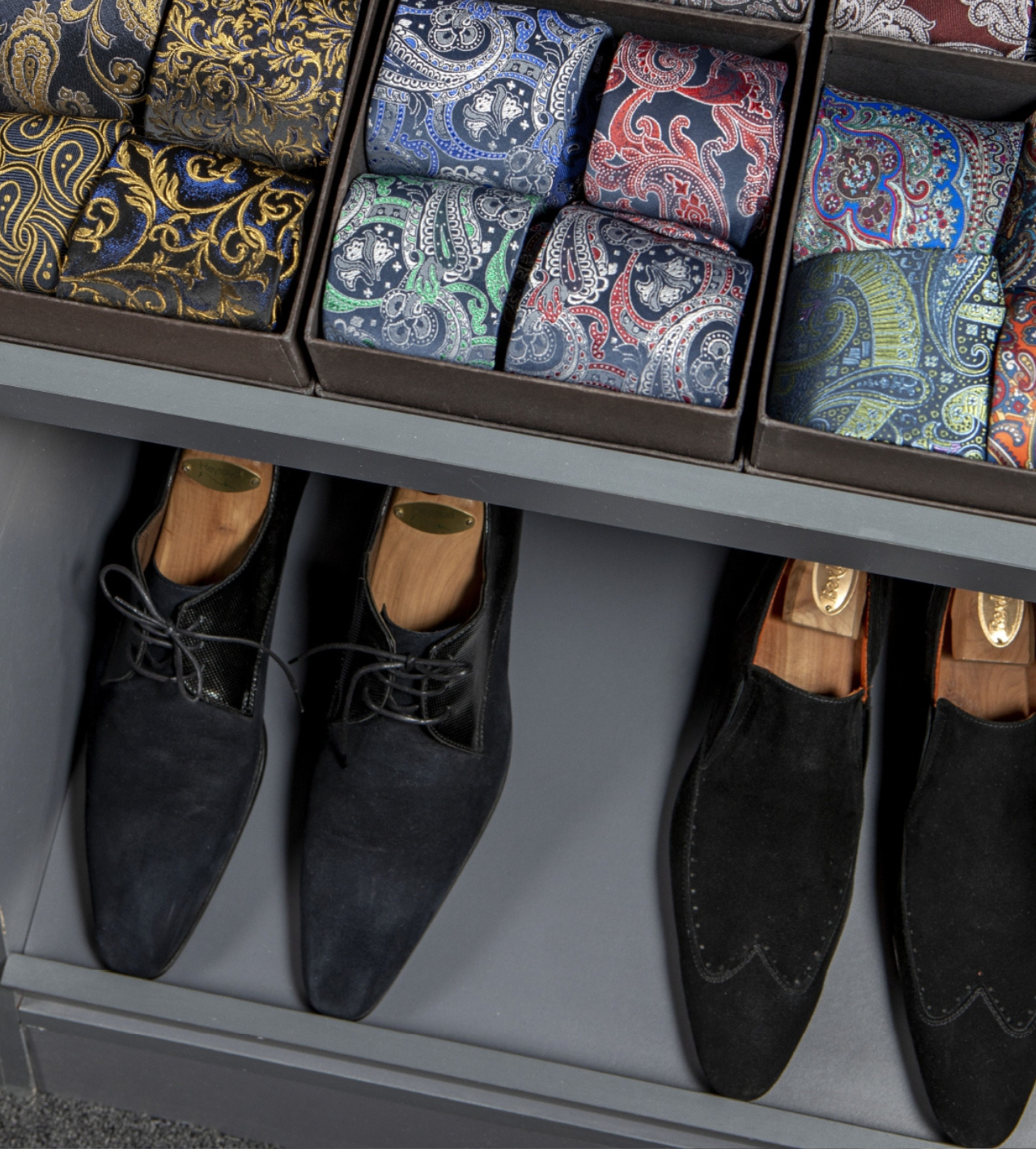 Un estante lleno de cajas de corbatas y zapatos