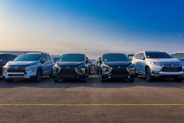 Quatro SUVs estacionadas lado a lado em um terreno baldio sob um céu azul.
