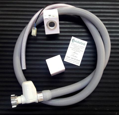 Una manguera para lavadora está sobre una alfombra negra