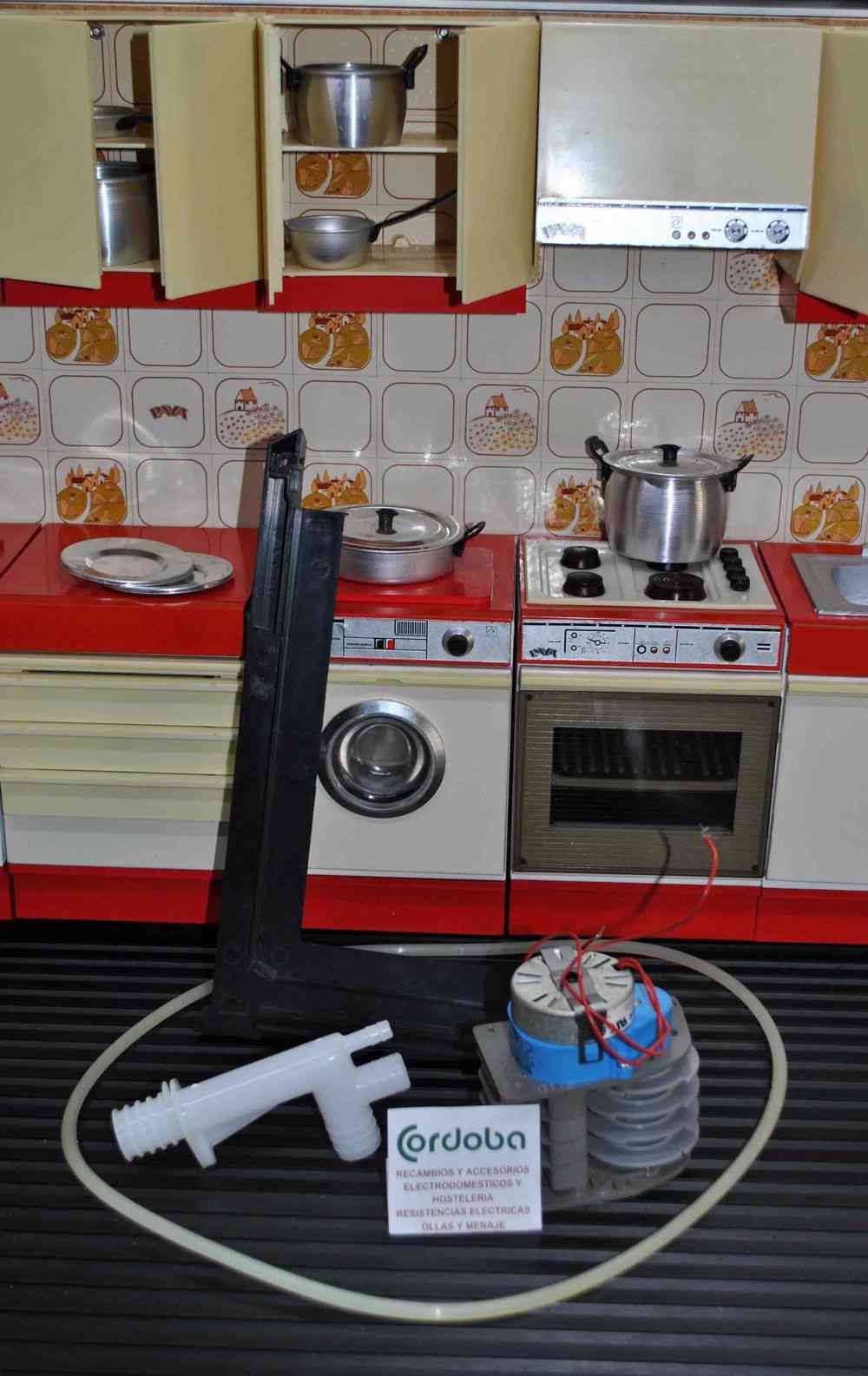 Una cocina con lavadora, secadora, horno, ollas y sartenes.