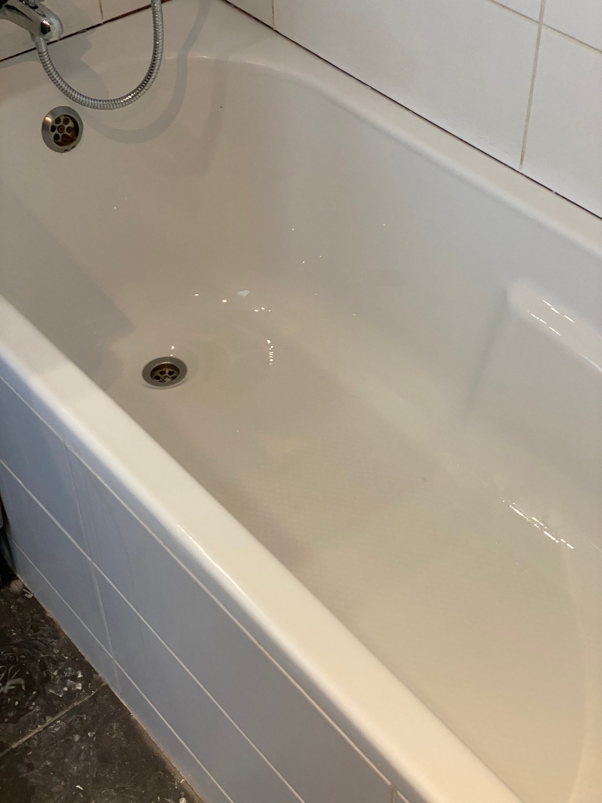Baignoire blanche dans une salle de bains carrelée.