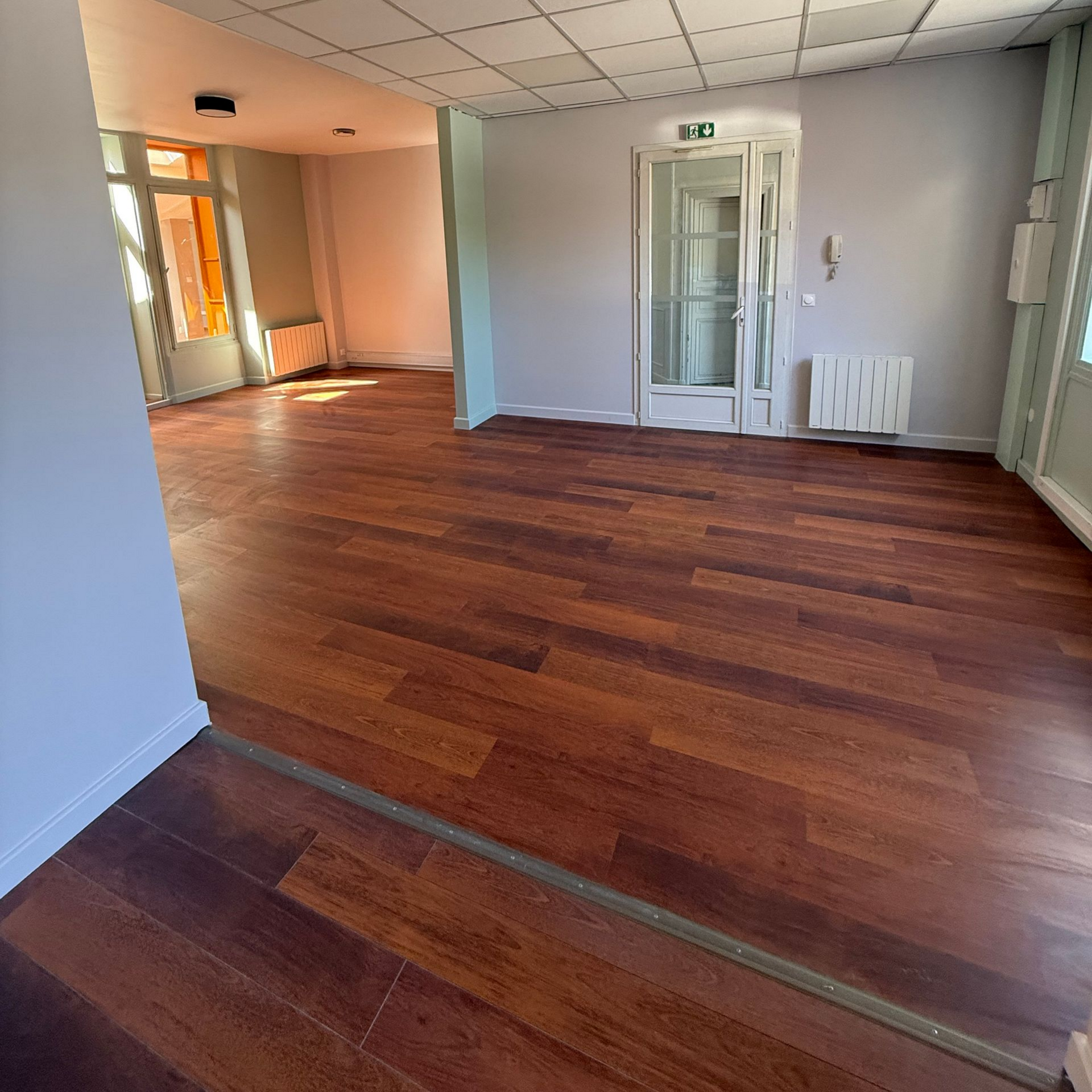 Pièce vide avec parquet foncé.