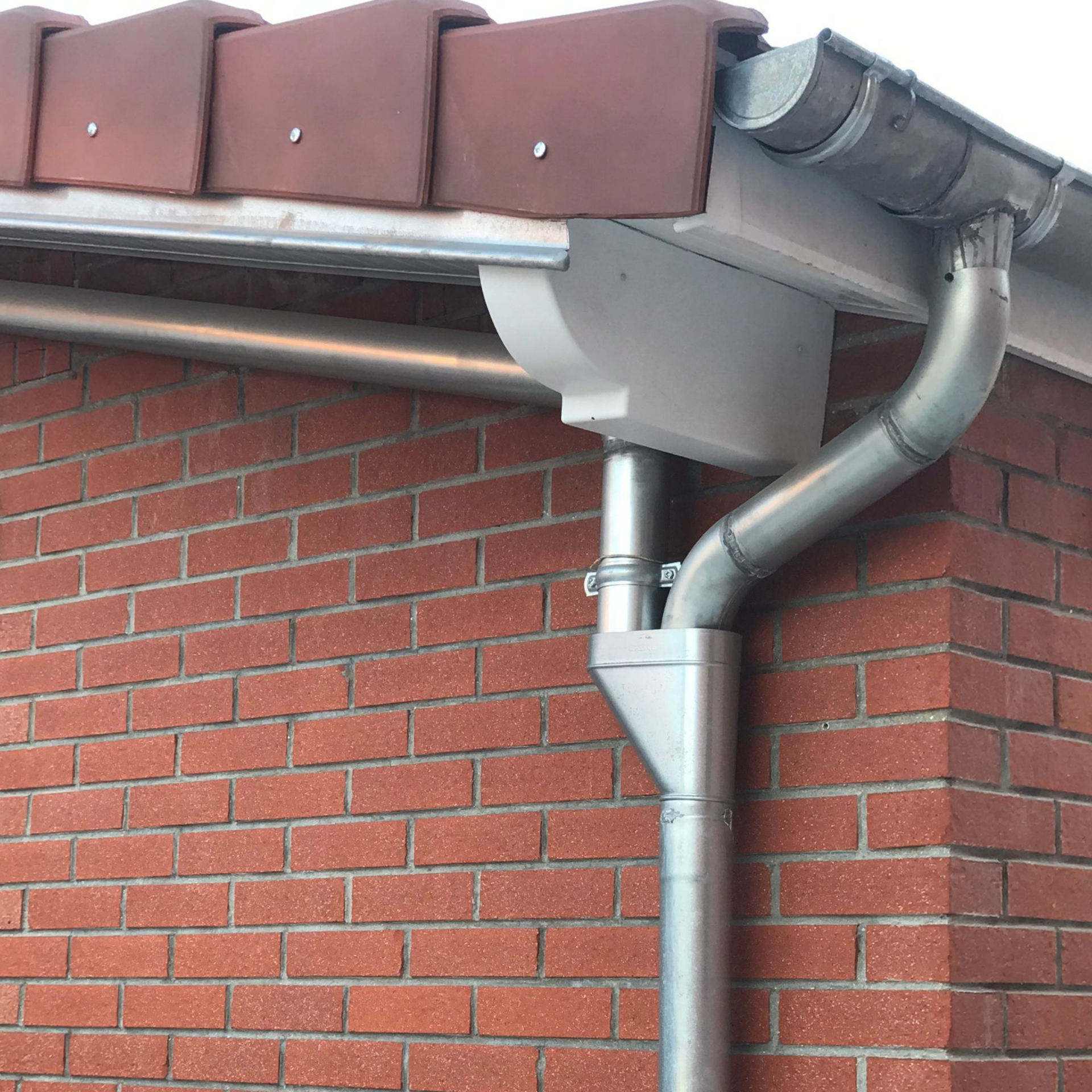 Bâtiment en briques avec système de gouttières métalliques.