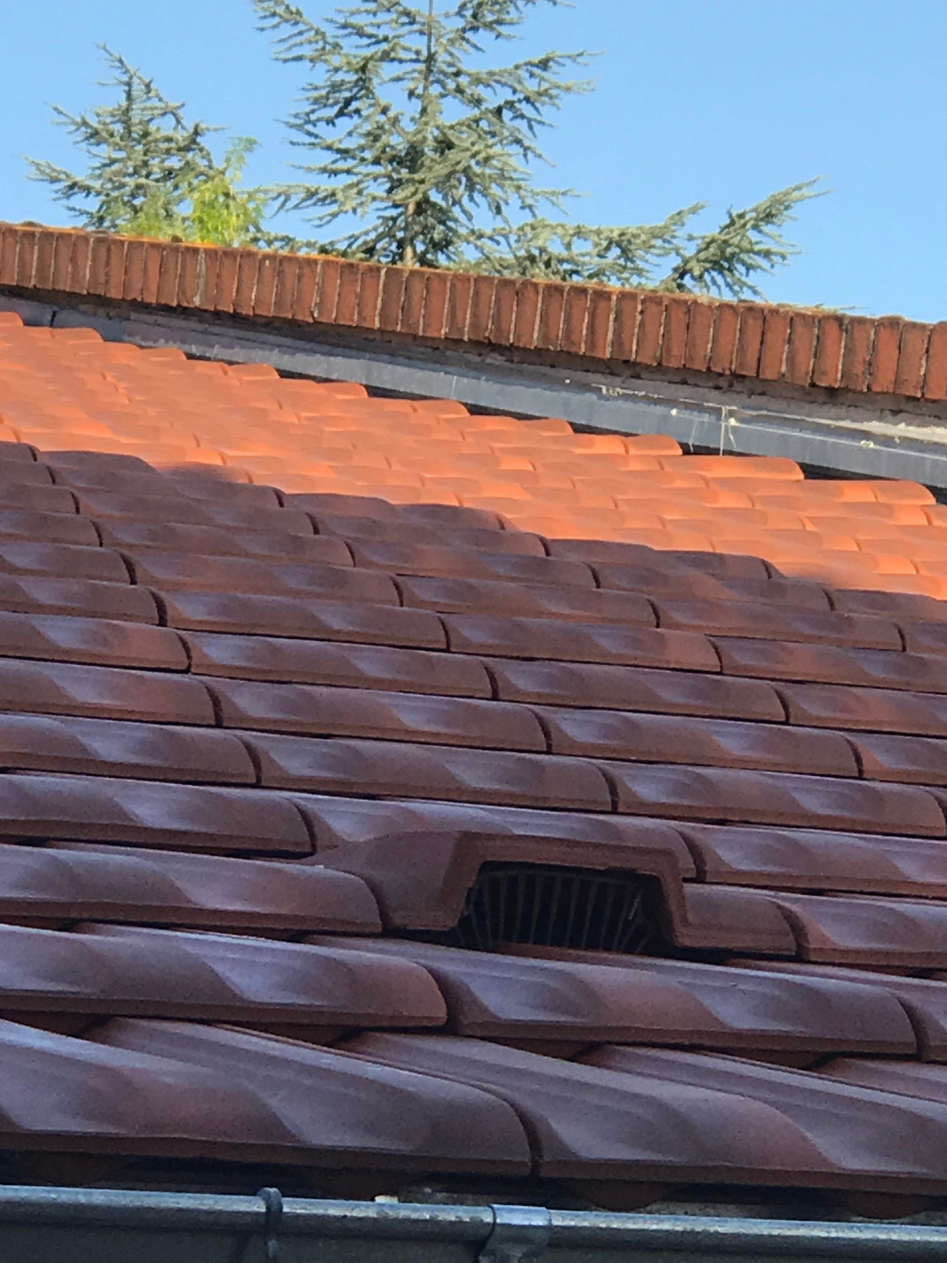 Gros plan sur un toit de tuiles rouges.