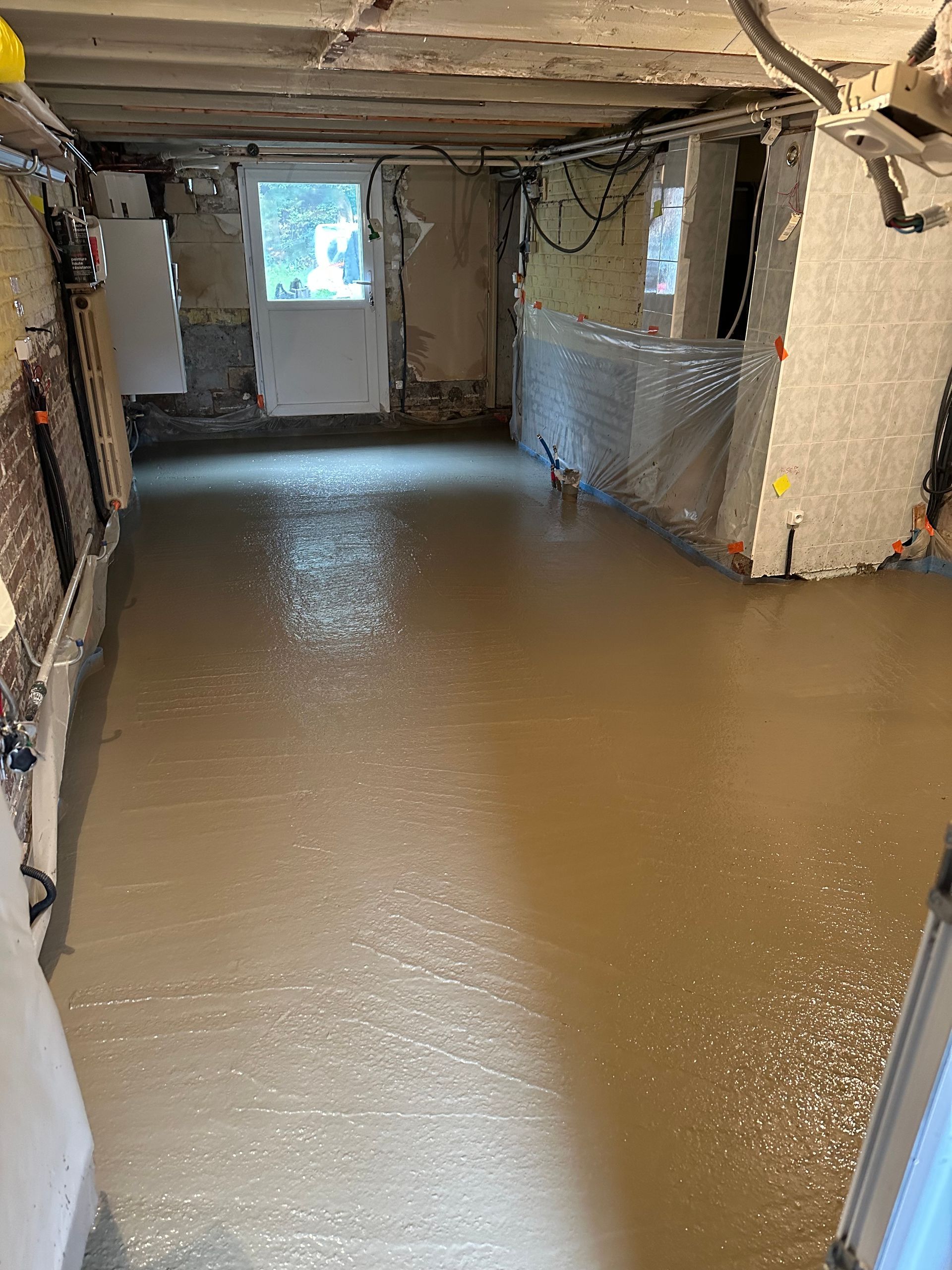 Sol en béton fraîchement coulé dans un sous-sol.