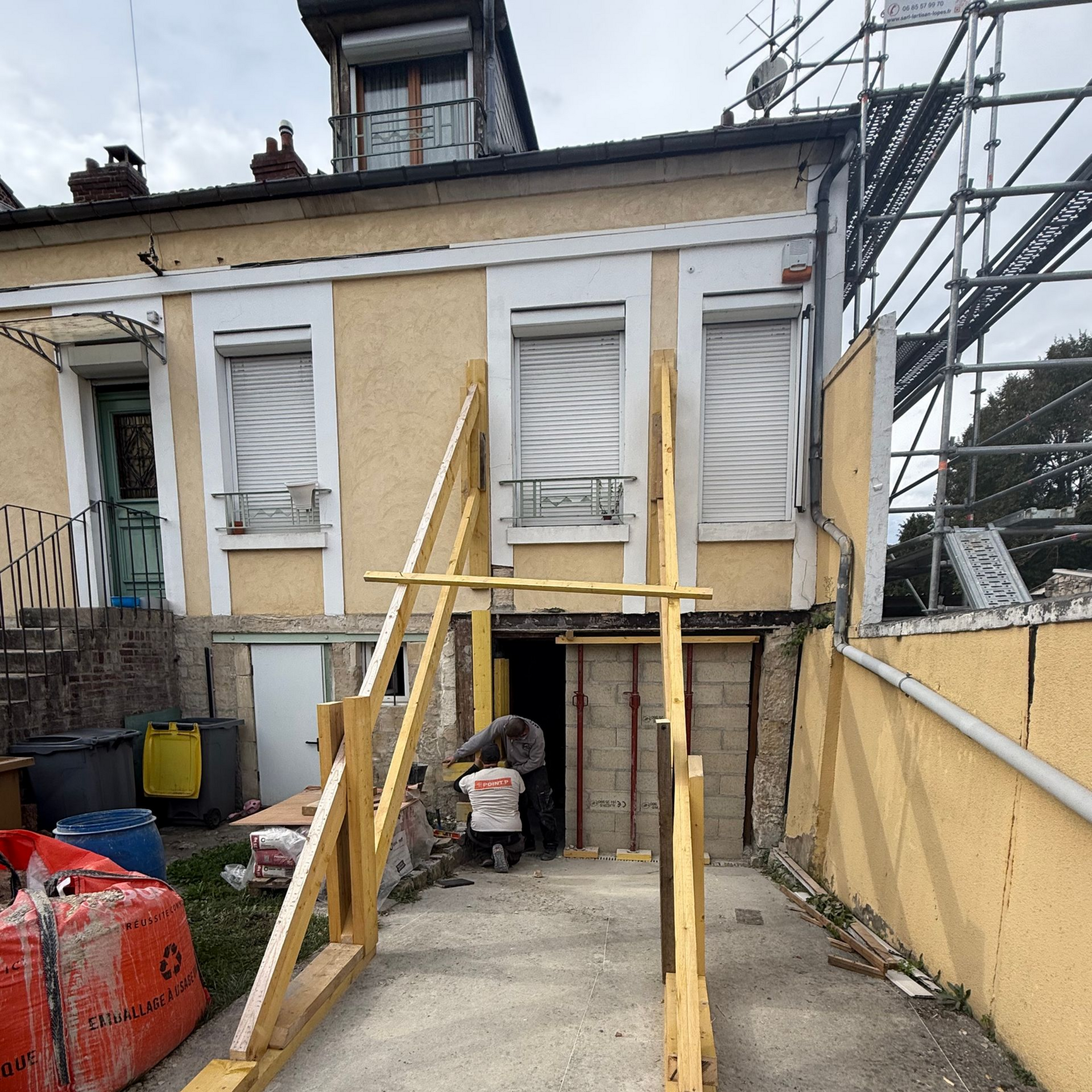Une maison en construction avec poutres et échafaudages.