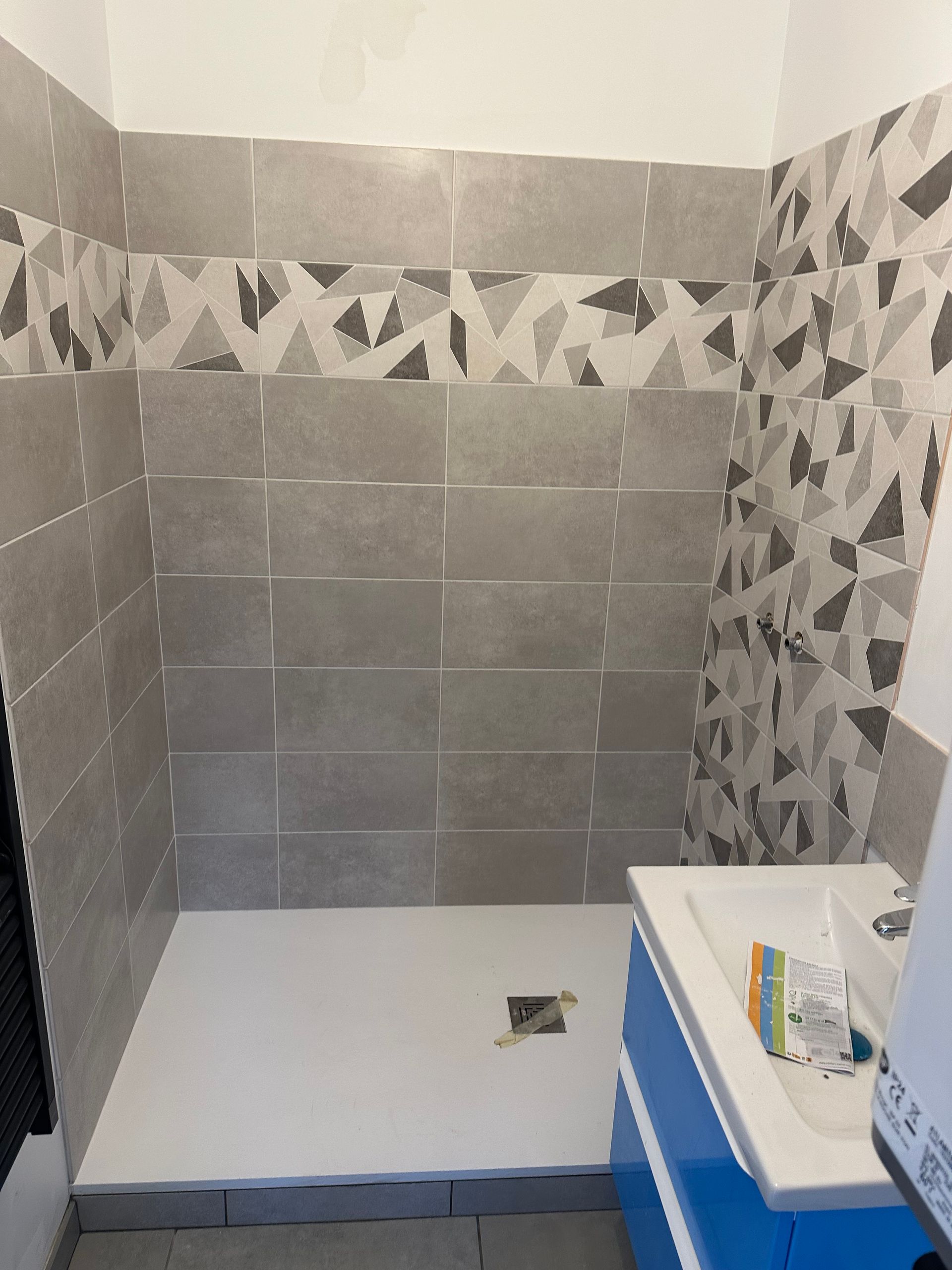 Salle de bains avec douche carrelée.