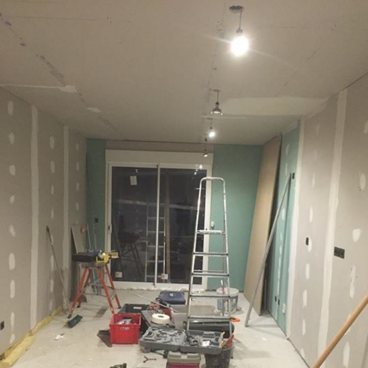 Pièce en rénovation, avec des murs blancs.