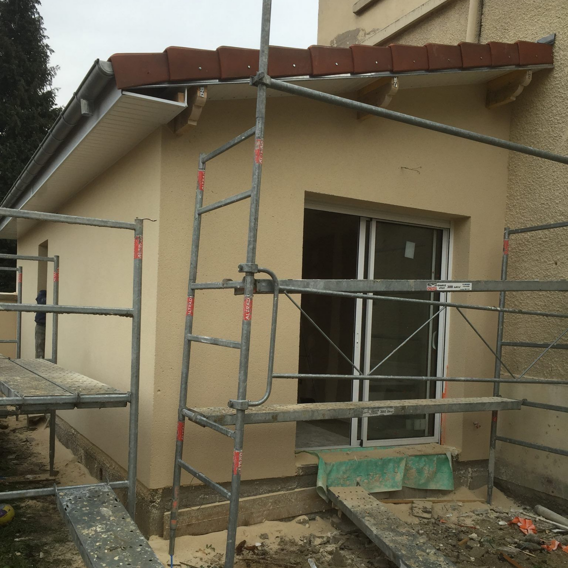 Extérieur d'une extension de bâtiment en construction, avec échafaudages.