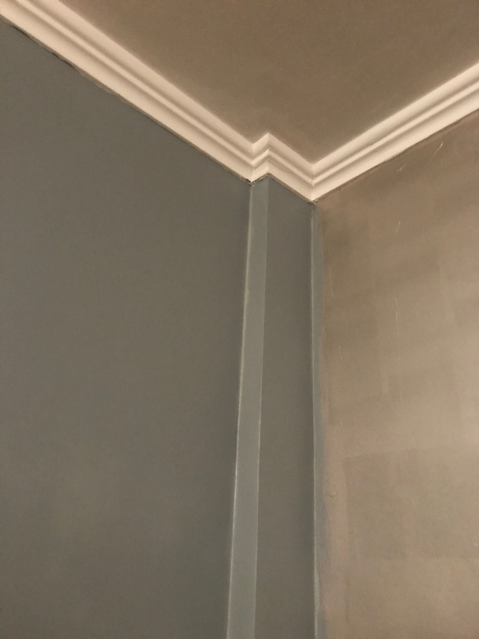 Coin d'une pièce avec moulures blanches, murs avant et après peinture.