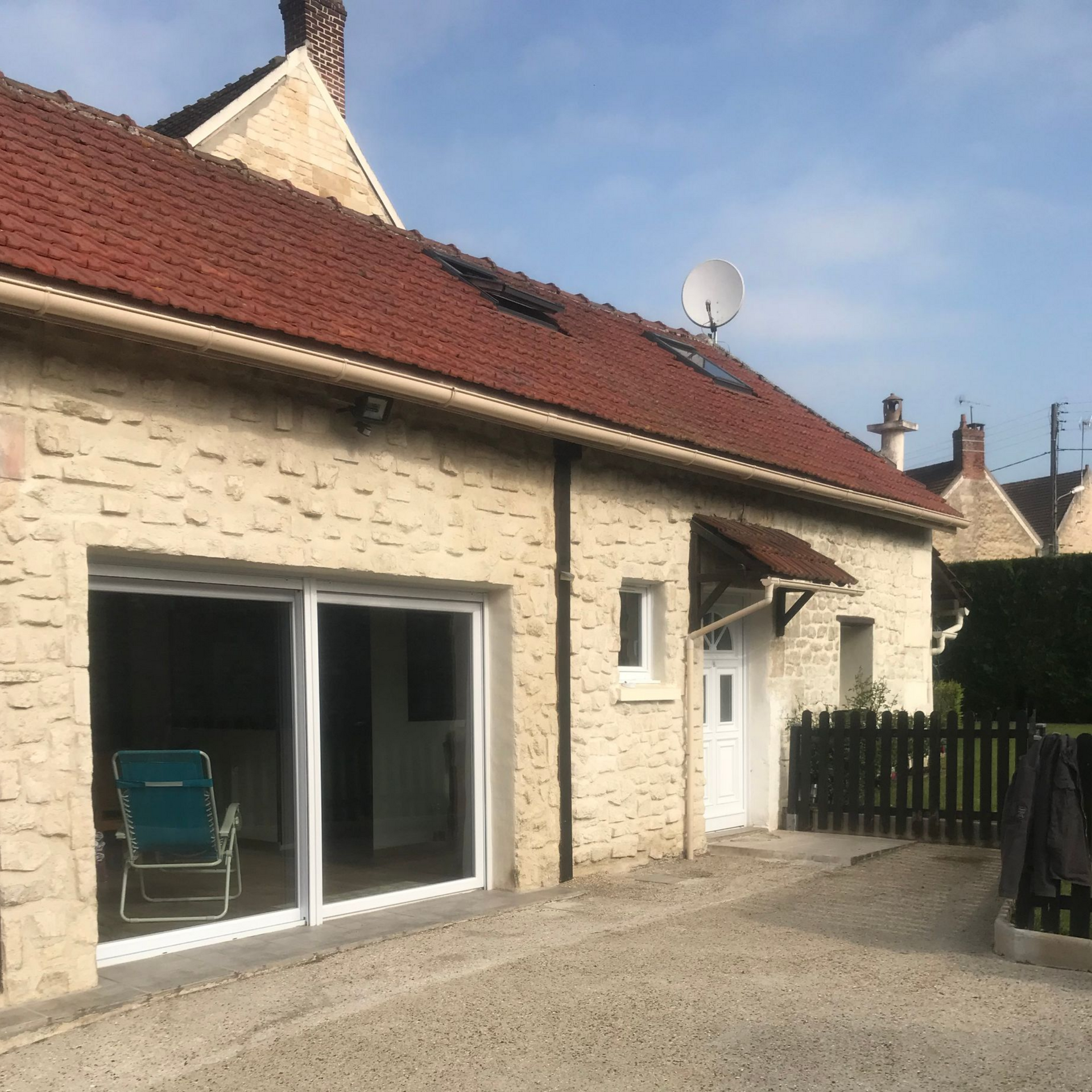 Toiture en tuiles rouges et en métal, avec deux puits de lumière.