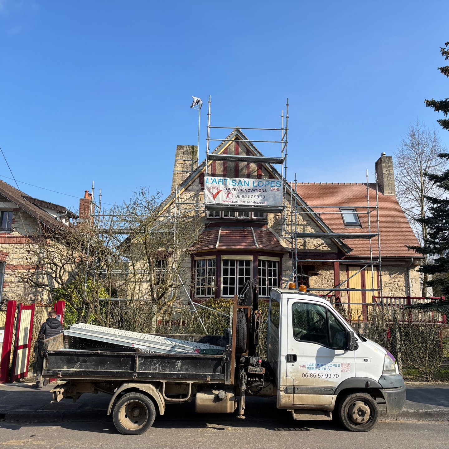Camion garé devant une maison en rénovation.