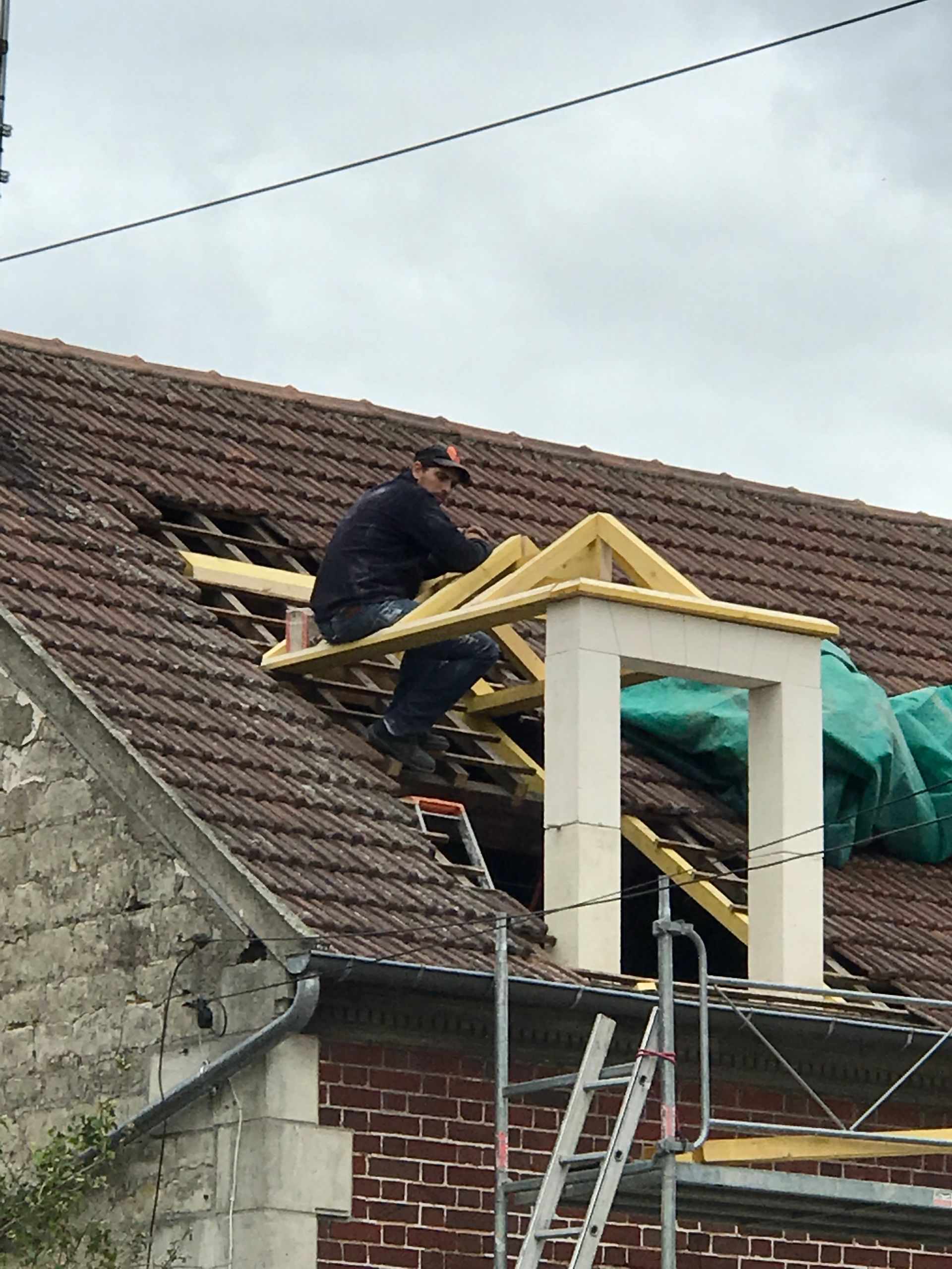 Une personne travaille à la réparation d'un toit.