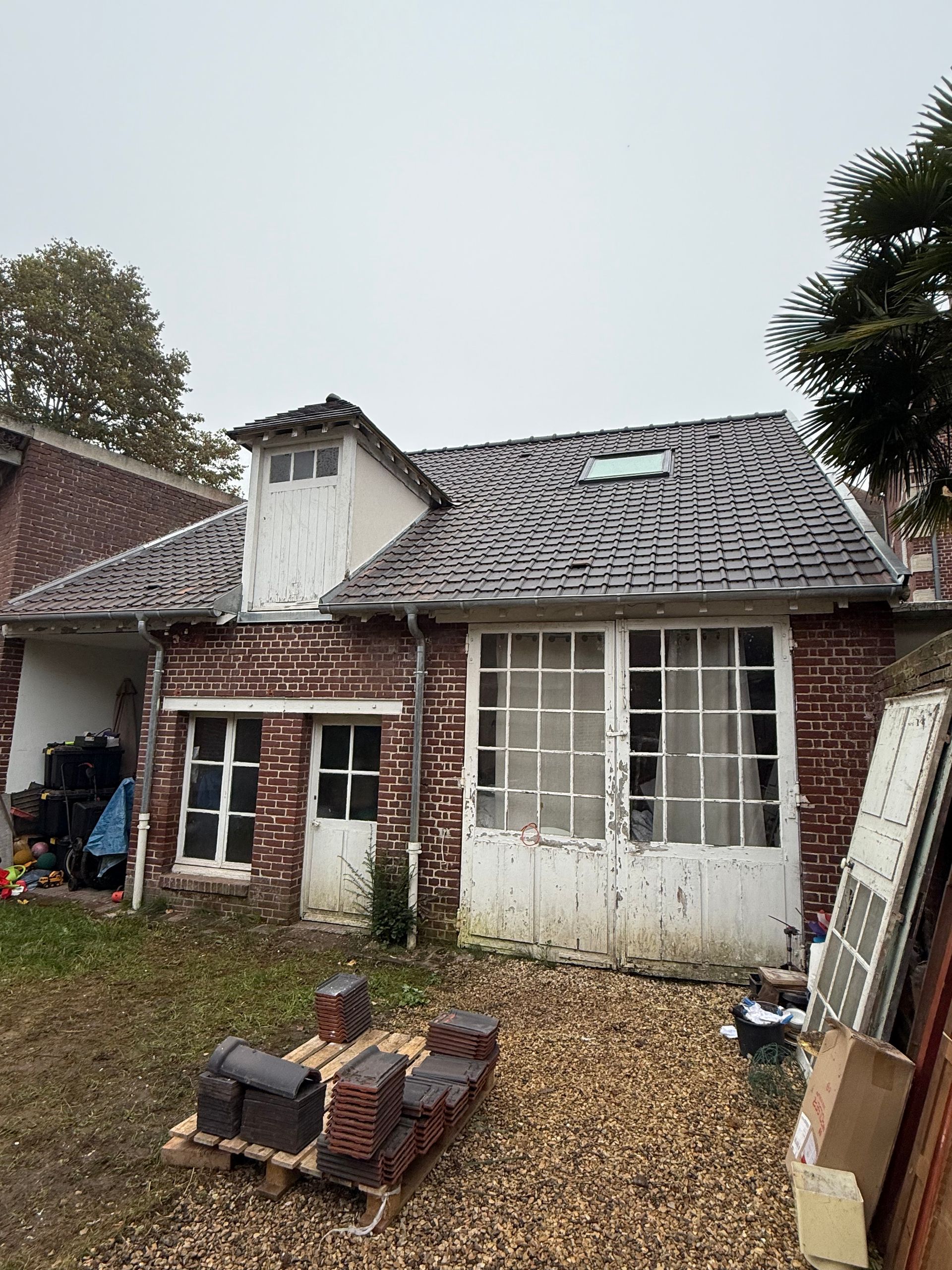Maison avec des murs en briques et un toit en tuiles.