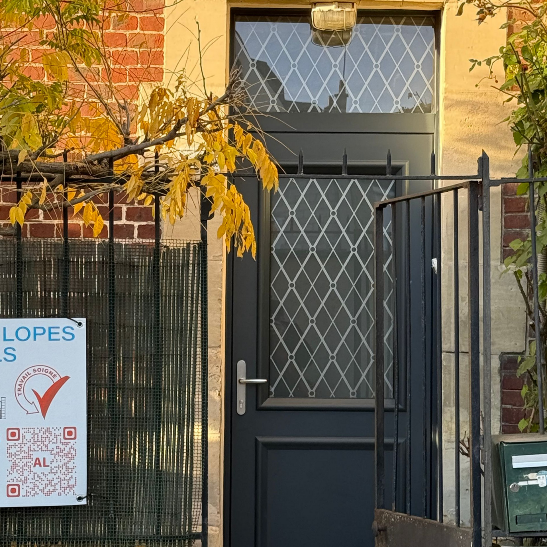 Toiture en tuiles rouges et en métal, avec deux puits de lumière.