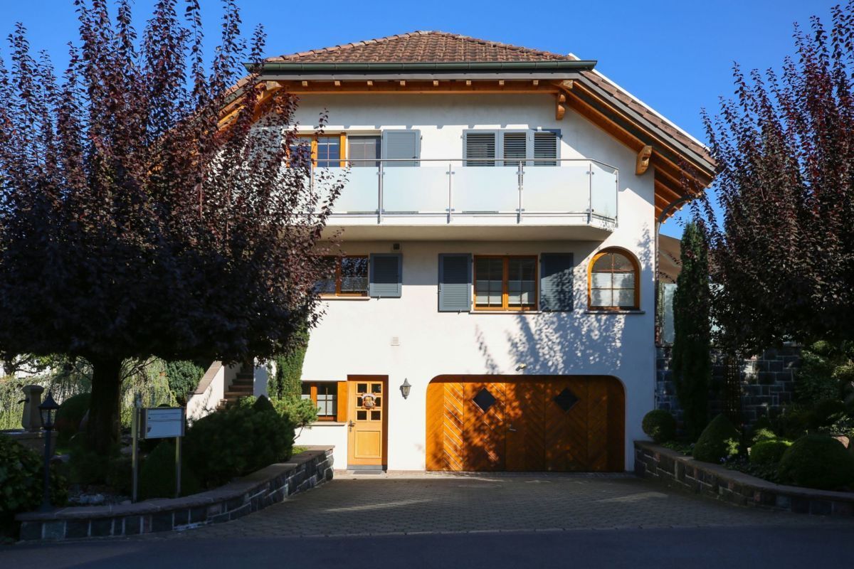 Einfamilienhaus mit Aluminiumläden, Balkon und grossem Garagentor